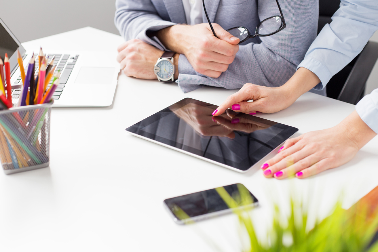 Two colleagues at work looking at tablet computer